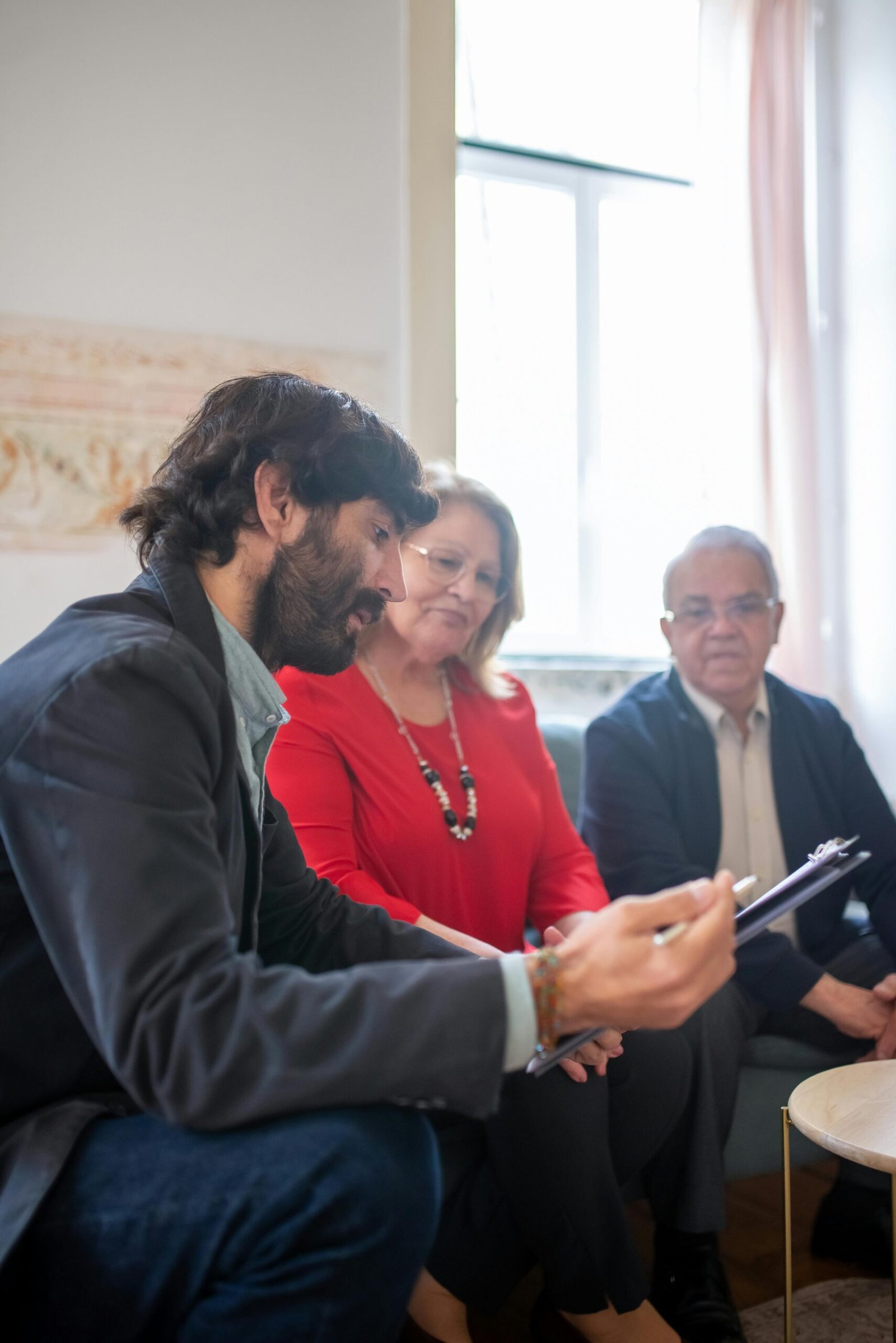 Consulting agent discussing documents with senior couple indoors during a business meeting.